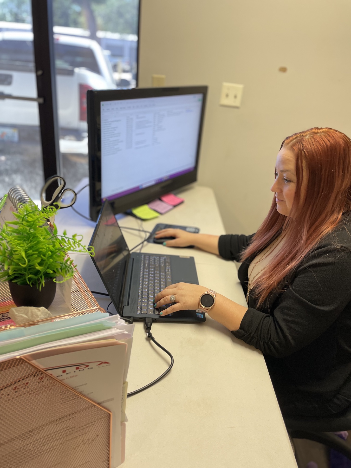 Office administrator managing permits and scheduling at her desk